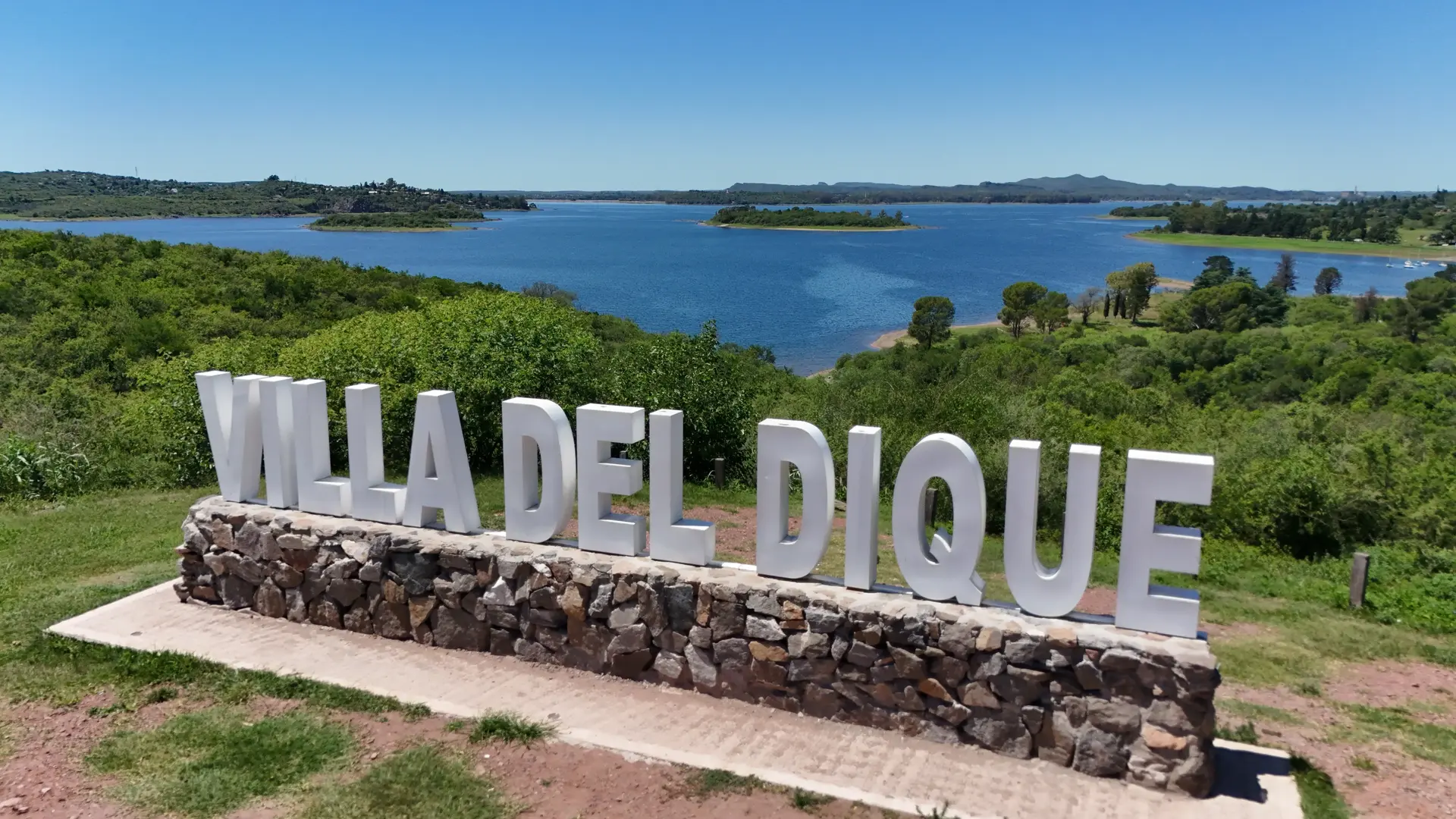Sendero de la Costa - Cartel de Villa del Dique con vista panorámica del lago